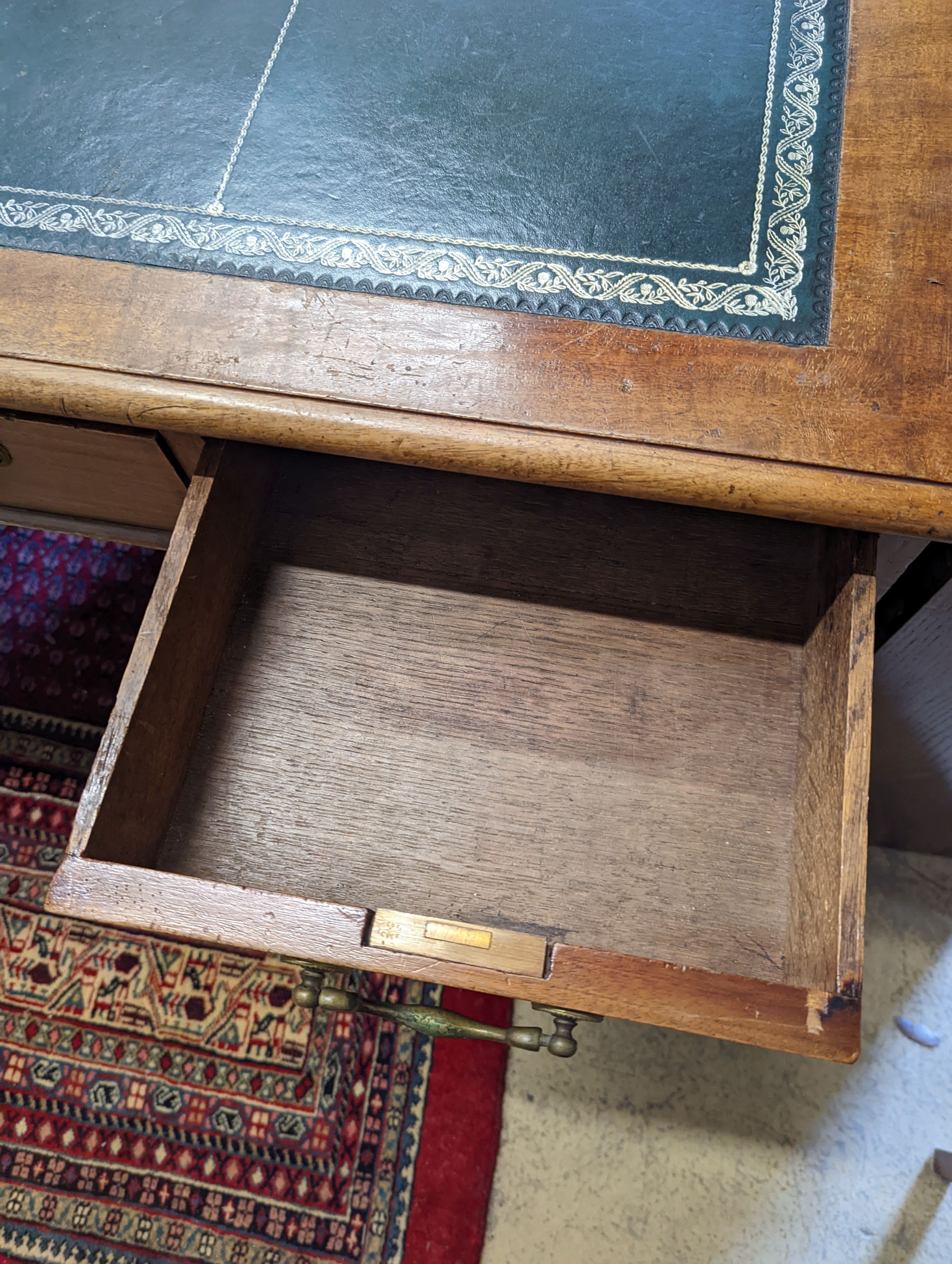 An Edwardian faded mahogany pedestal desk, stamped T. Willson, Great Queen Street, London, length 136cm, depth 76cm, height 76cm